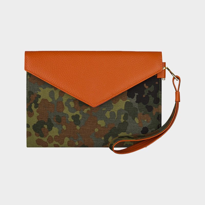 Clutch-Tasche mit Camouflage-Muster und orangefarbener Klappe im Umschlagstil. An einer Seite ist eine orangefarbene Handschlaufe angebracht.